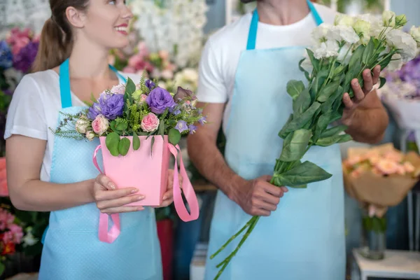 Närbild av manliga och kvinnliga händer som håller blommor i blomsteraffär — Stockfoto