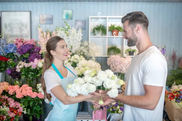 Barbu mâle acheter des fleurs blanches de sourire fleuriste femelle — Photo