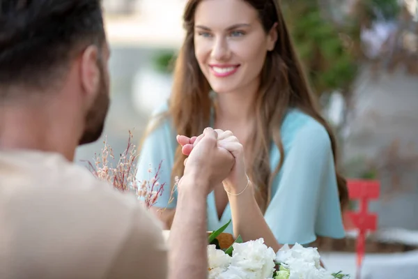Bearded male and female looking at each other, holding hands — Stock Photo, Image