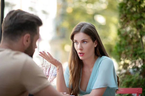 Triste pareja sentada en un café al aire libre, discutiendo entre sí — Foto de Stock