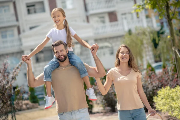 Jovem família feliz andando e sorrindo positivamente — Fotografia de Stock
