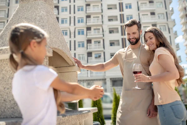 Young family having barbeque in the yard — Stock Photo, Image