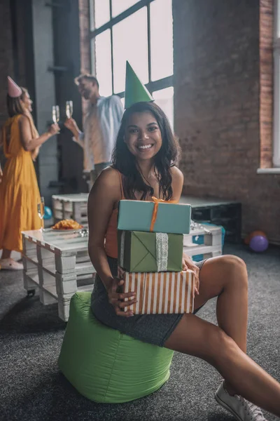 Uśmiechnięta kobieta trzyma stertę prezentów urodzinowych — Zdjęcie stockowe