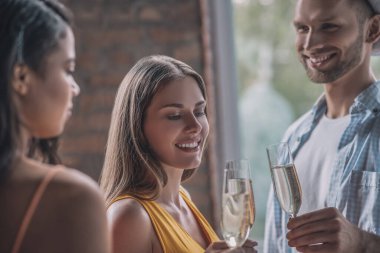 Üç gülen arkadaş birlikte güzel bir parti veriyor.