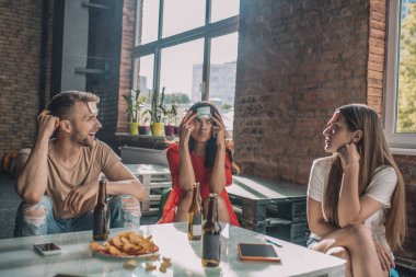 Arkadaşlar yapışkan notlarla oyun oynuyorlar