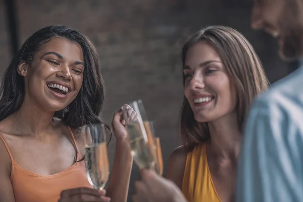 Радостные друзья звенят бокалами шампанского — стоковое фото