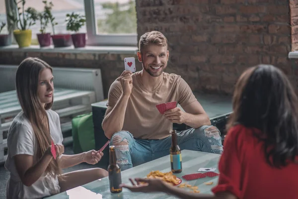 Друзья пьют пиво и играют в карты вместе — стоковое фото