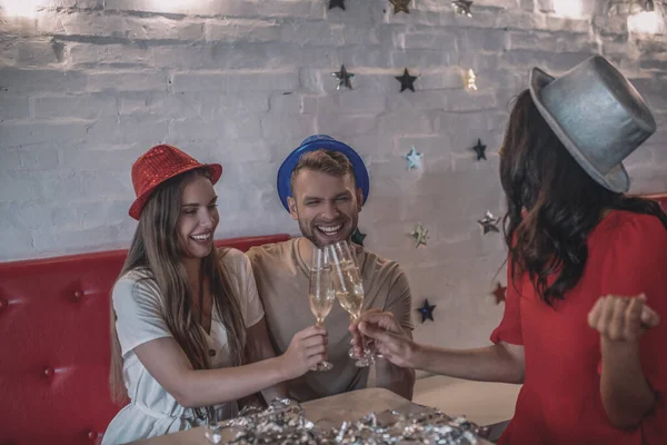 Amigos sonrientes tintineando sus copas de champán —  Fotos de Stock