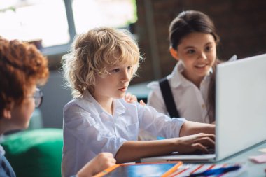 Sınıfta ders çalışan üç sevimli çocuk.