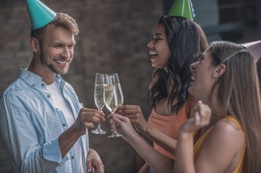Arkadaşlar doğum günü partisinde kadehlerini şaklatıyorlar.