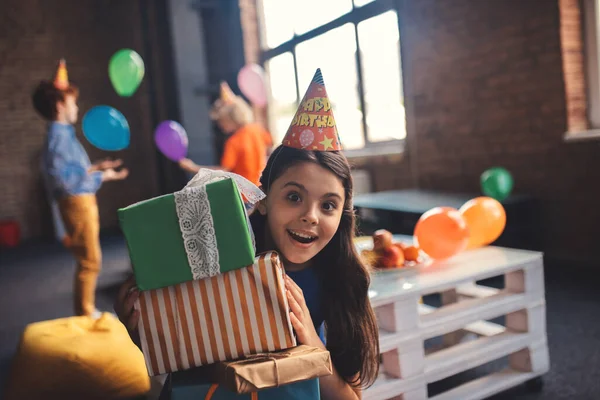 Cute girl w kapeluszu gospodarstwa prezenty i uczucie szczęścia — Zdjęcie stockowe