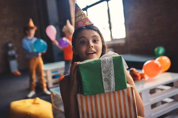 Gadis manis dalam topi memegang hadiah dan merasa bersemangat — Stok Foto