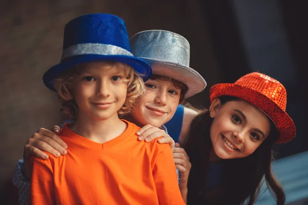 Tres amigos en sombreros de fiesta luciendo felices —  Fotos de Stock