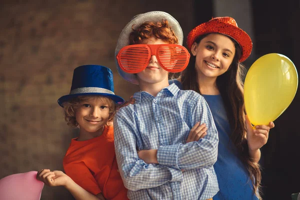 Tres niños con sombreros de fiesta posando para la foto — Foto de Stock