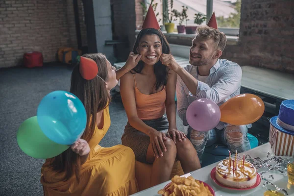 Друзі торкаються жіночих щік під час дня народження — стокове фото