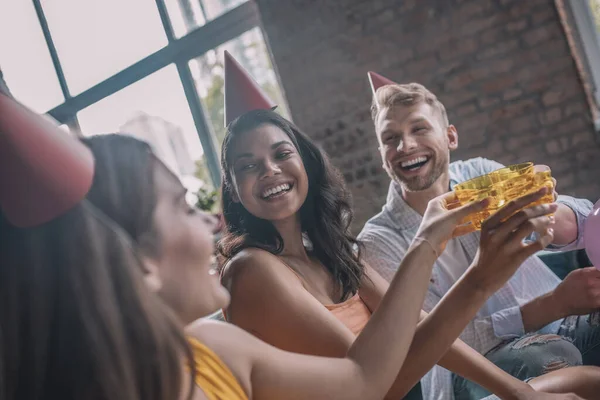 Трое улыбающихся друзей пили алкоголь во время празднования дня рождения — стоковое фото