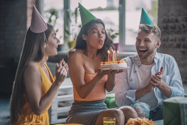 Mujer feliz soplando velas en su pastel de cumpleaños — Foto de Stock