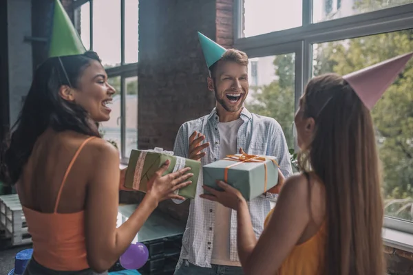 Şaşırmış bir adam arkadaşlarından bir sürü hediye alıyor.