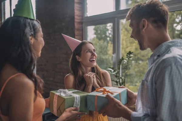 Emocionada mujer recibiendo sus regalos de cumpleaños de amigos —  Fotos de Stock