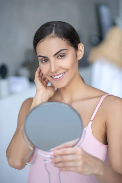 Mujer linda en lencería rosa sosteniendo un espejo — Foto de Stock