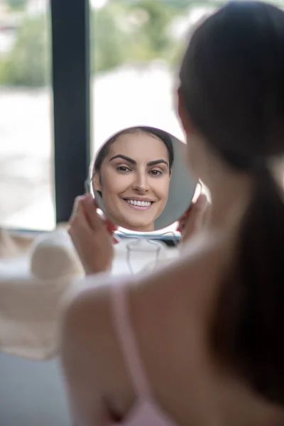 Mujer linda en lencería rosa sintiéndose bien mirándose a sí misma — Foto de Stock