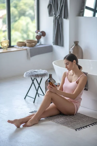 Young cute woman sitting in the bathroom — Stock Photo, Image