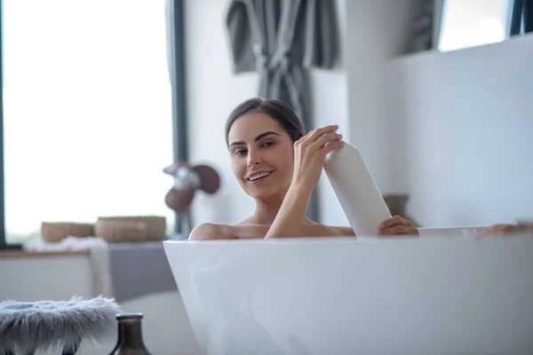 Žena se koupe a vypadá potěšeně — Stock fotografie