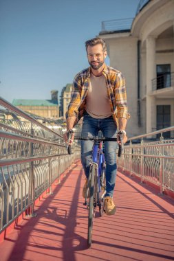 Bisikletli bir adam kameraya doğru gidiyor.