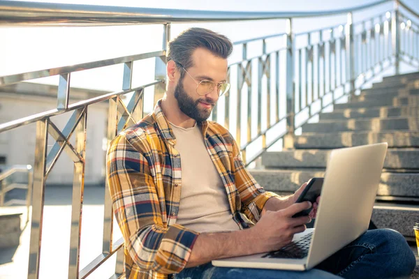 Man met bril en smartphone op stappen — Stockfoto