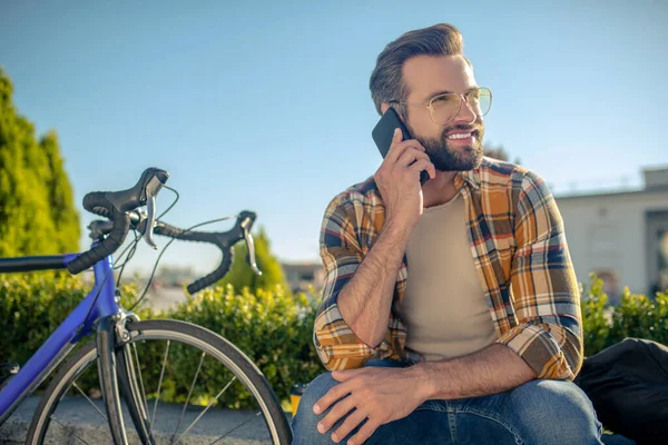 Hombre sonriente tranquilo con teléfono inteligente cerca de la oreja — Foto de Stock