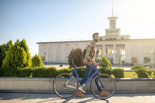 Homme heureux avec vélo marchant dans la ville — Photo