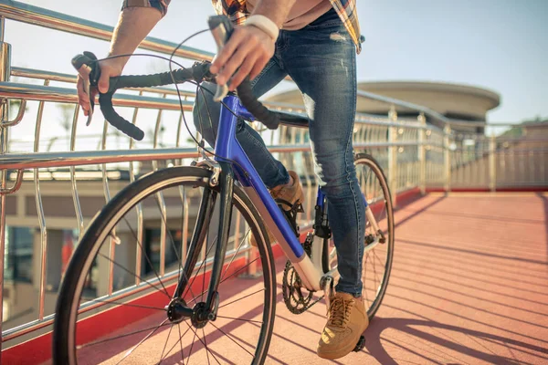 Piernas masculinas en jeans sobre pedales de bicicleta de montar — Foto de Stock
