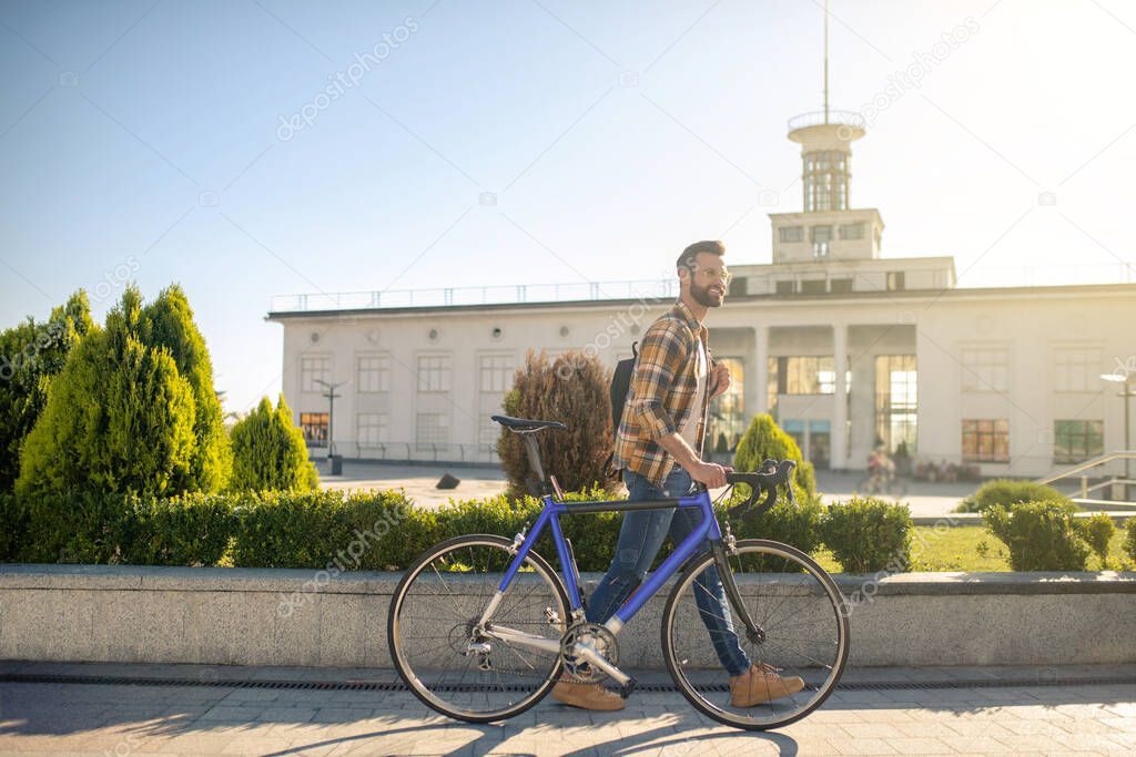 Happy man with bike walking in the city