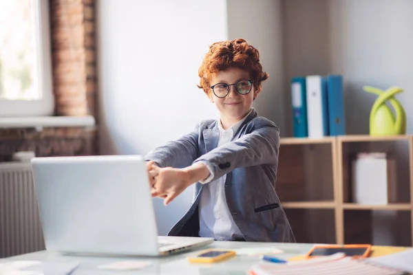 Roodharige jongen in zitten aan de laptop en stretching — Stockfoto