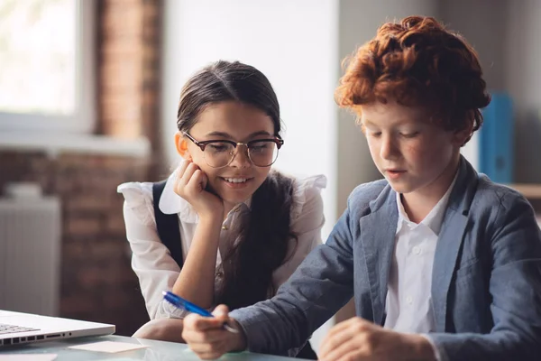 Dunkelhaariges Mädchen erklärt Klassenkameradin Lektion — Stockfoto