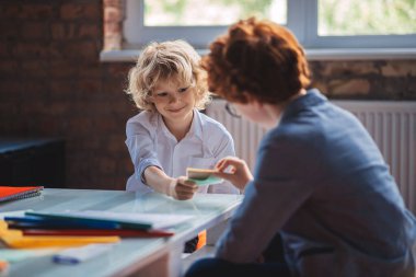 Sınıfta oynayan iki çocuk heyecanlanıyor.