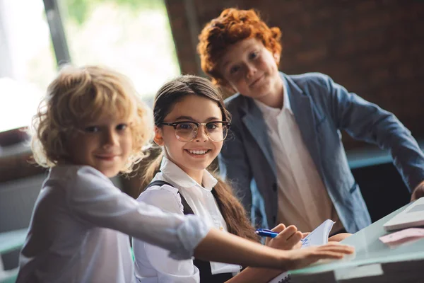 Drei süße Kinder lernen im Klassenzimmer und sind aufgeregt — Stockfoto