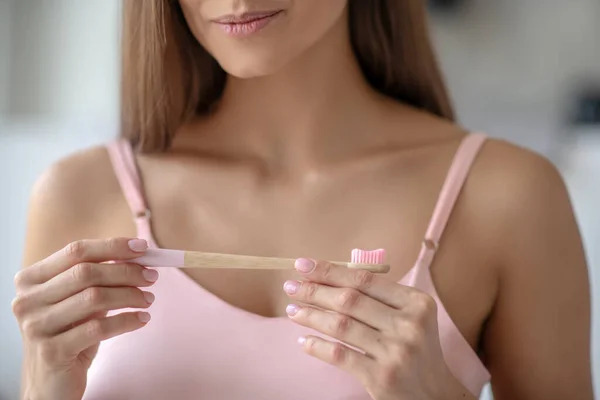 Mulher segurando uma escova de dentes em suas mãos — Fotografia de Stock