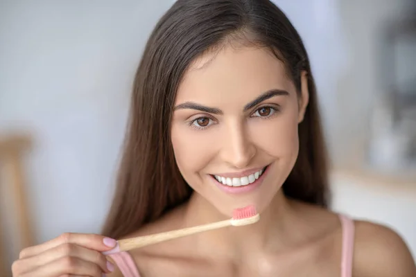 Красива жінка чистить зуби і посміхається — стокове фото
