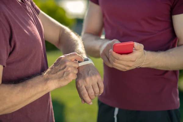 Akıllı ve akıllı telefonlara sahip iki çift erkek eli yakın plan. — Stok fotoğraf