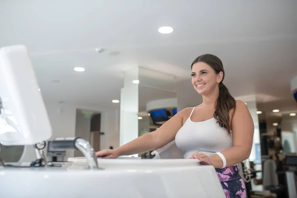 Sorrindo jovem mulher usando novos equipamentos esportivos — Fotografia de Stock