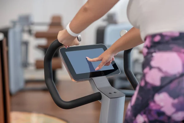 Donna che utilizza una cyclette con un touch screen — Foto Stock