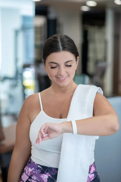 Mulher olhando para o rastreador de fitness durante o treinamento — Fotografia de Stock