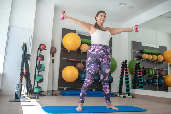 Kadın spor salonunda yoga dersleri alıyor.