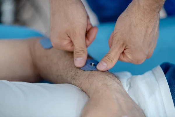 Detailní záběr rukou fyzioterapeuta aplikujících podložku na zápěstí pacienta — Stock fotografie