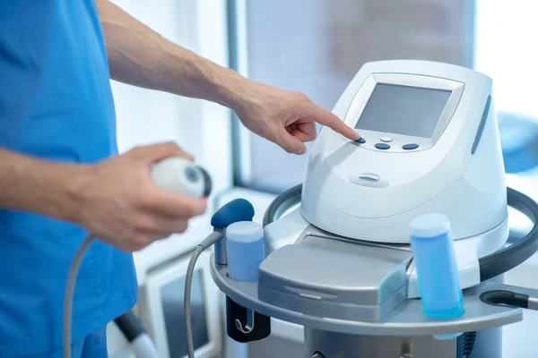 Close-up de mãos masculinas ajuste de configurações na máquina de ultra-som fisioterapia — Fotografia de Stock