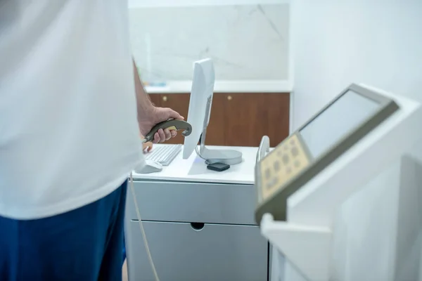 顔のない医療機器の近くの白いTシャツの男 — ストック写真