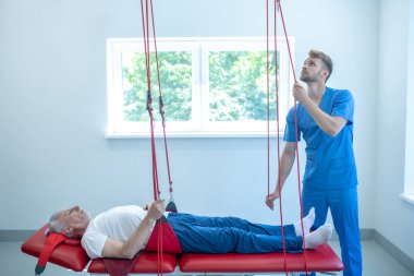 Rehabilitasyonda kanepede yatan yaşlı bir adam.