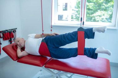 Çalışkan yaşlı hasta tıp merkezinde rehabilitasyon yapıyor.