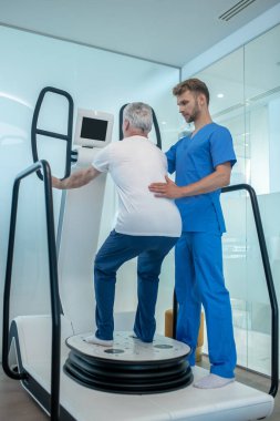 Tıp Merkezi 'ndeki rehabilitasyon doktoru ve yaşlı hasta.